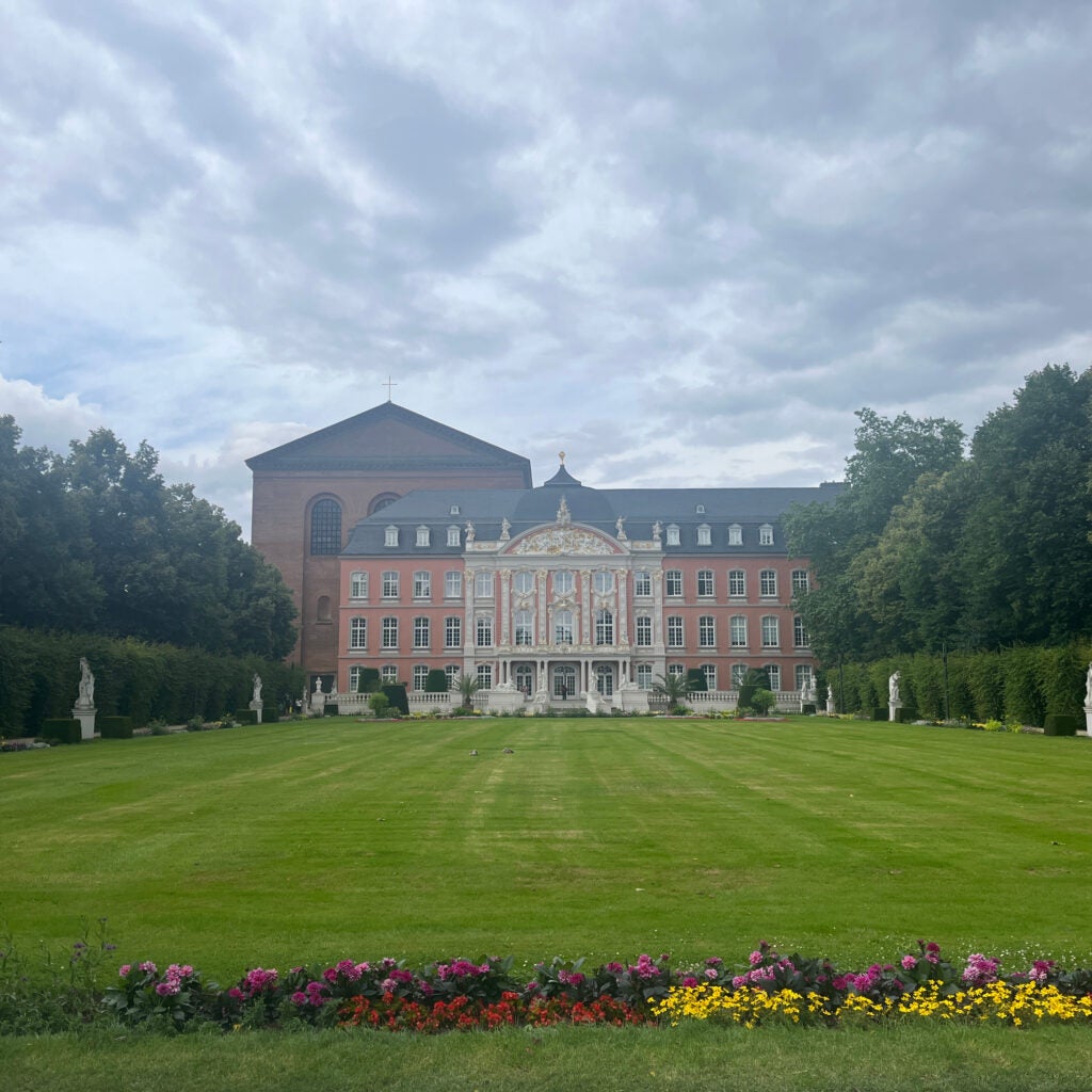 Flowers and green lawn in front of stately residence