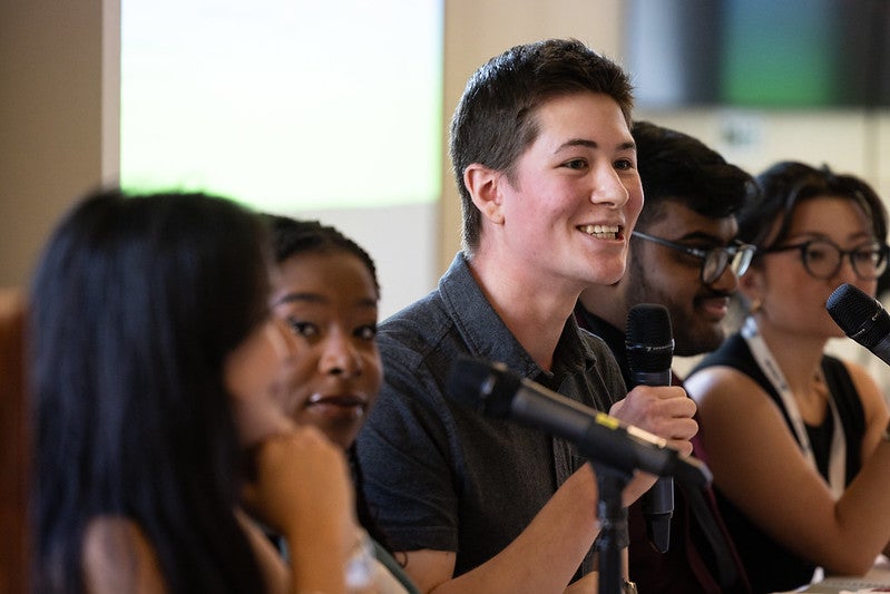 Andre Albrecht holds the microphone during the Laidlaw Scholars Conference at Columbia University