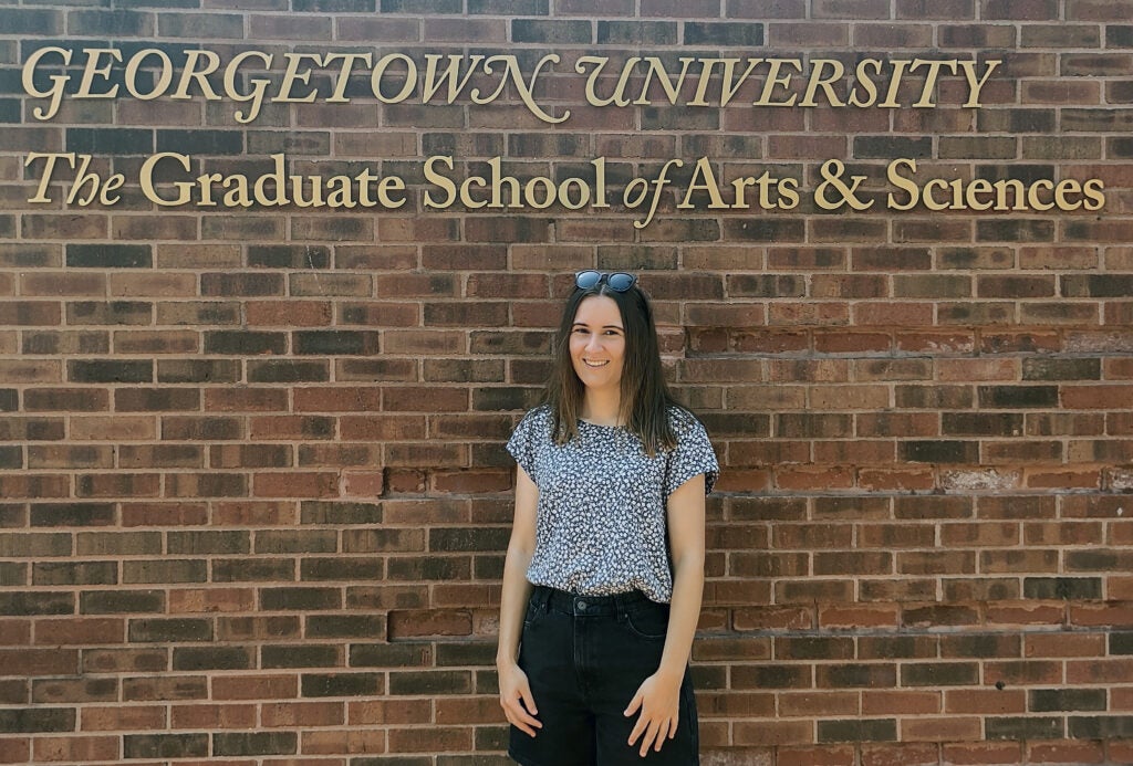 Visiting researcher Sandra Schell stands in front of the Georgetown University Graduate School