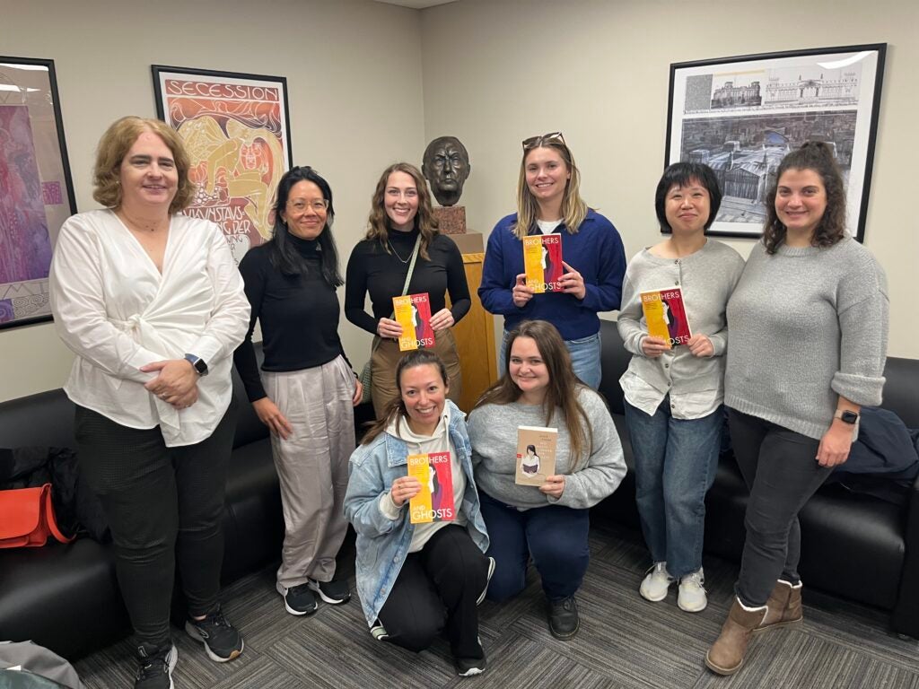 Professor Mary Helen Dupree and journalist Khuê Pham stand with six graduate students in front of a bust of Konrad Adenaur